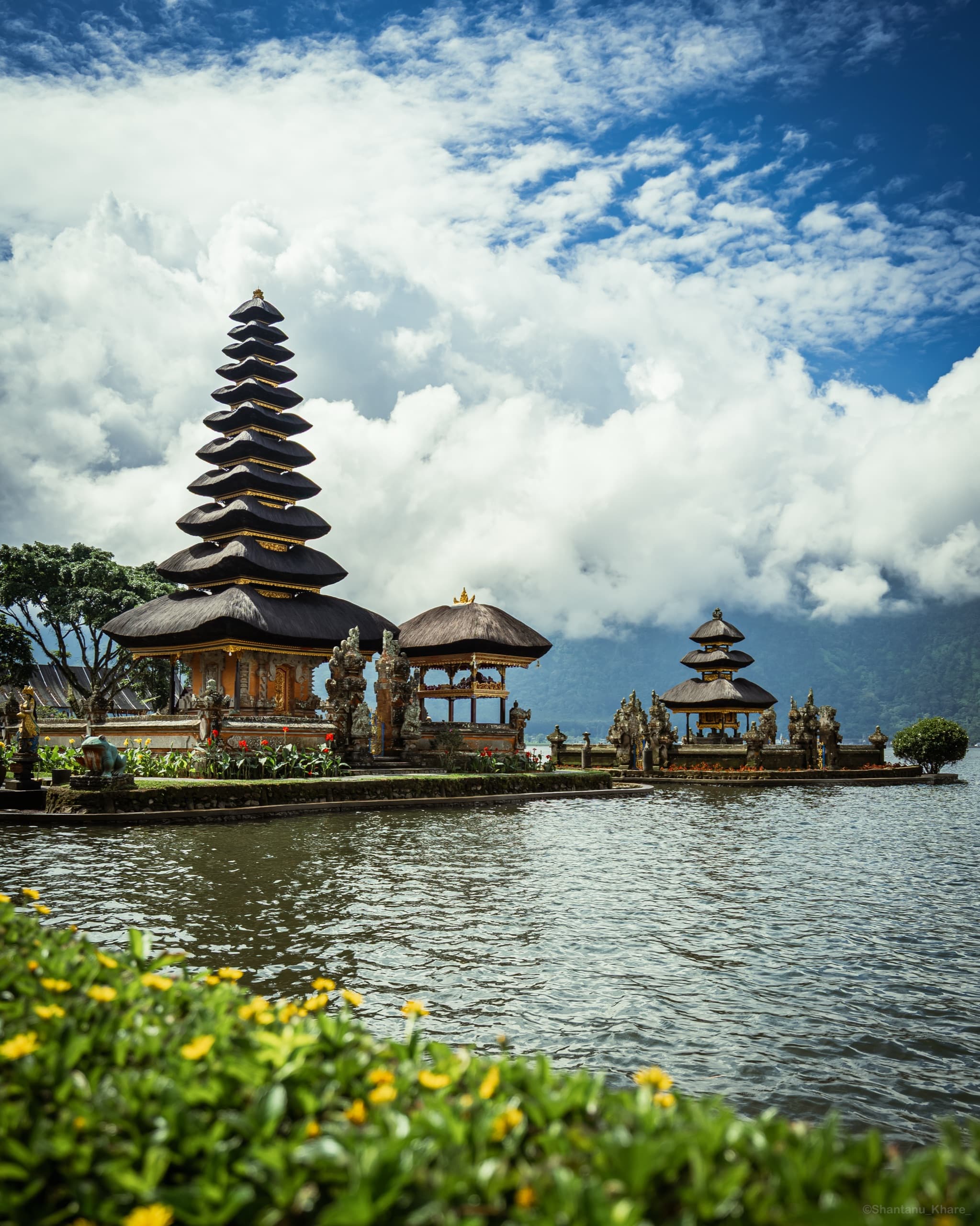 Travel photography — Ulun Danu Beratan temple over the lake beneath towering clouds, Bali.