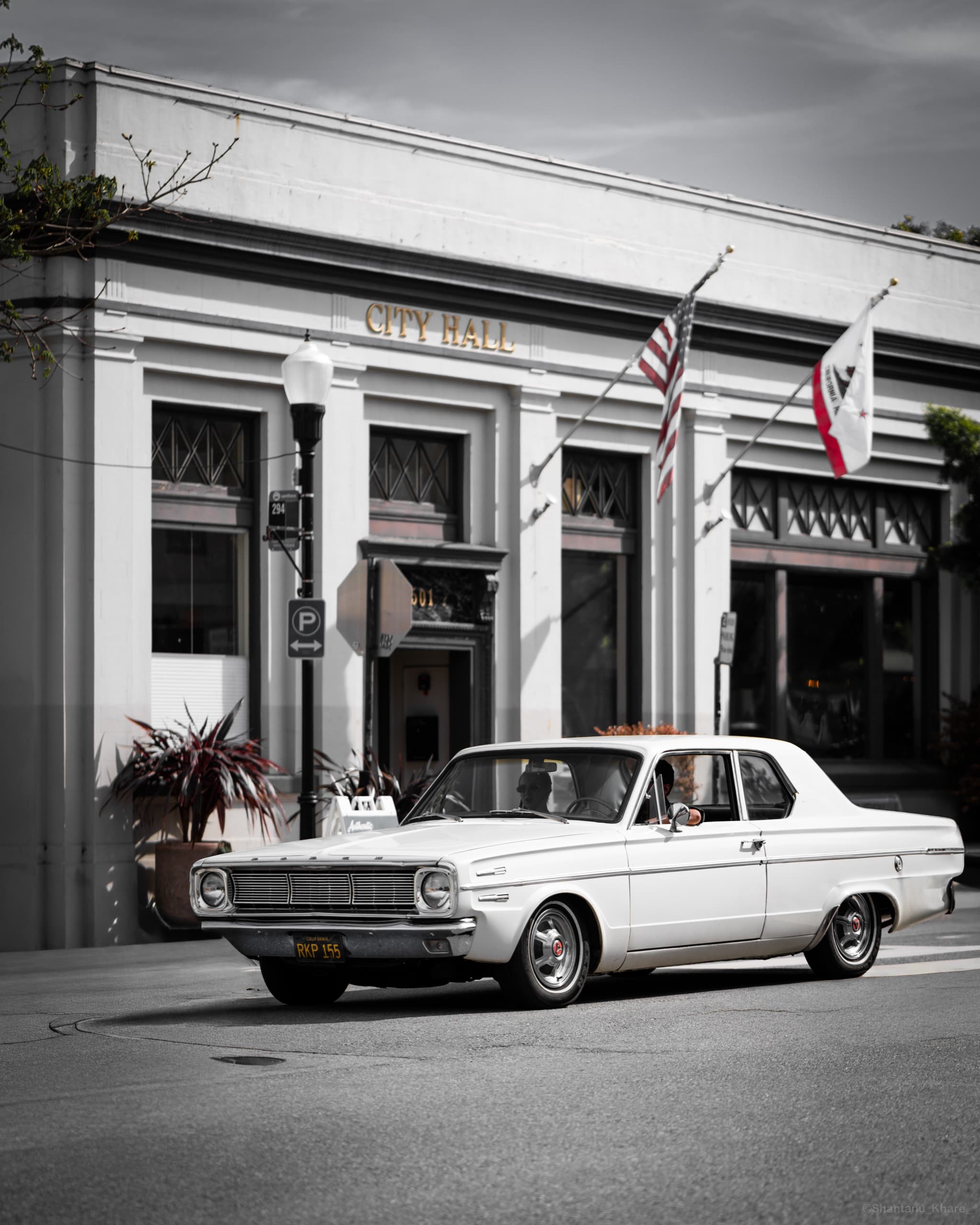 Automotive photography — a white vintage car before a classical City Hall facade.